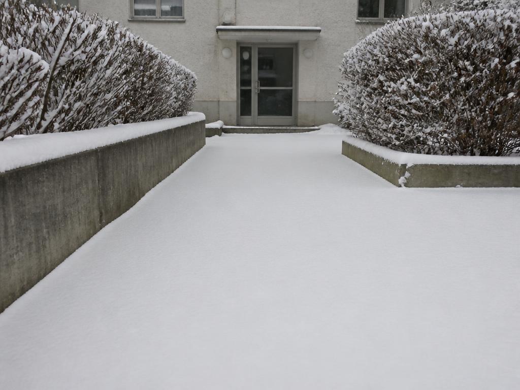 Verschneiter Gehweg vor einem Wohnhaus in Zürich